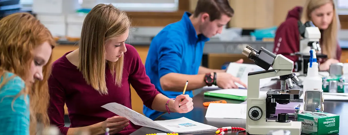 A group of students doing labwork in a biology lab.